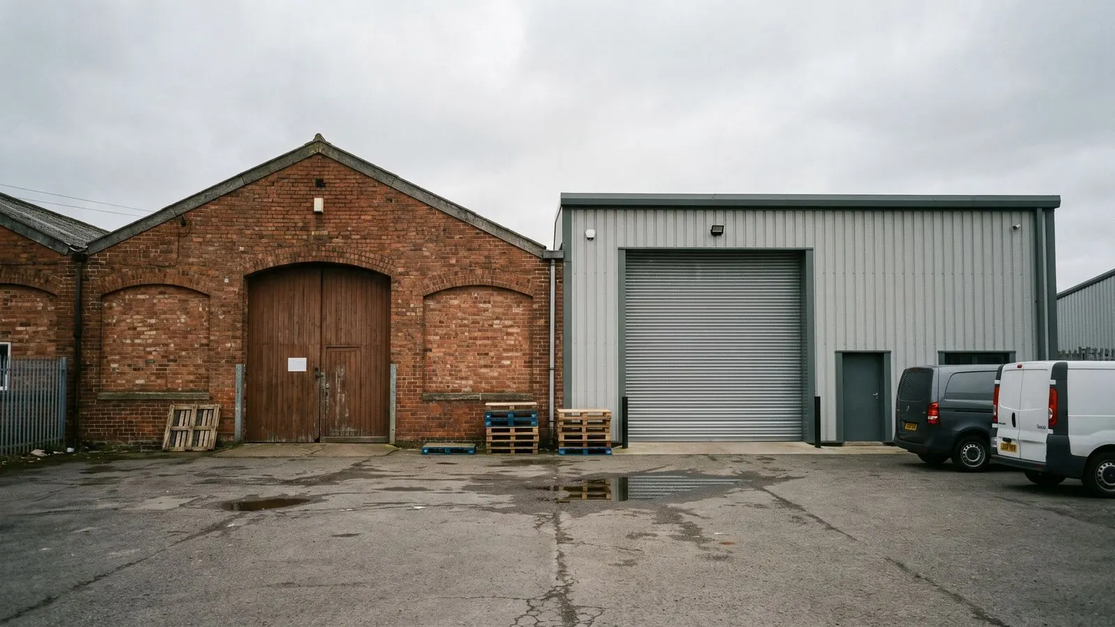 Two adjoining light-industrial units sharing a yard, one older and one newer
