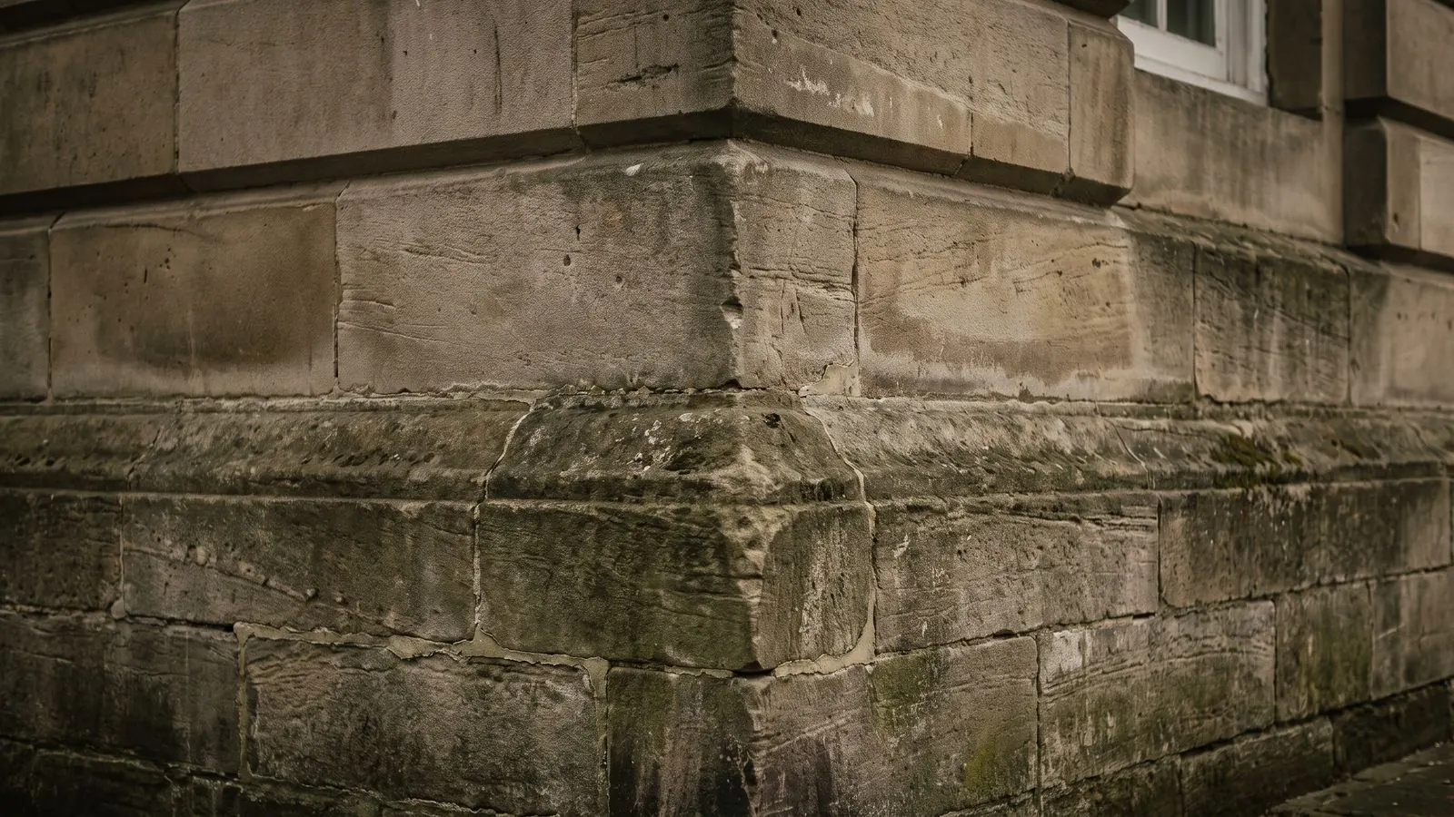 The cut stone cornerstone and lower courses of a commercial building